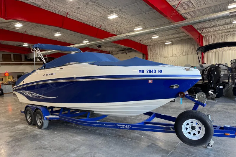 Slide: The Image of 2006 Rinker 246 boat in a showroom, blue and white design on trailer. - 20