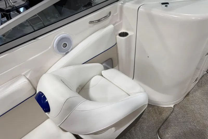 Slide: The Image of 2006 Rinker 246 boat interior with white seating and speaker detail. - 24