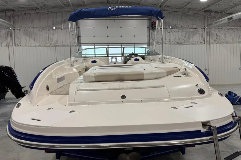 Slide: The Image of 2006 Rinker 246 boat with blue canopy in indoor storage facility. - 4