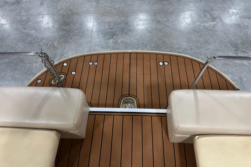 Slide: The Image of 2011 Bennington 2575 RCW I/O boat deck with beige seating and wood finish. - 13
