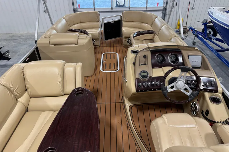 Slide: The Image of Luxurious interior of 2011 Bennington 2575 RCW I/O boat with beige seating and wooden flooring. - 9