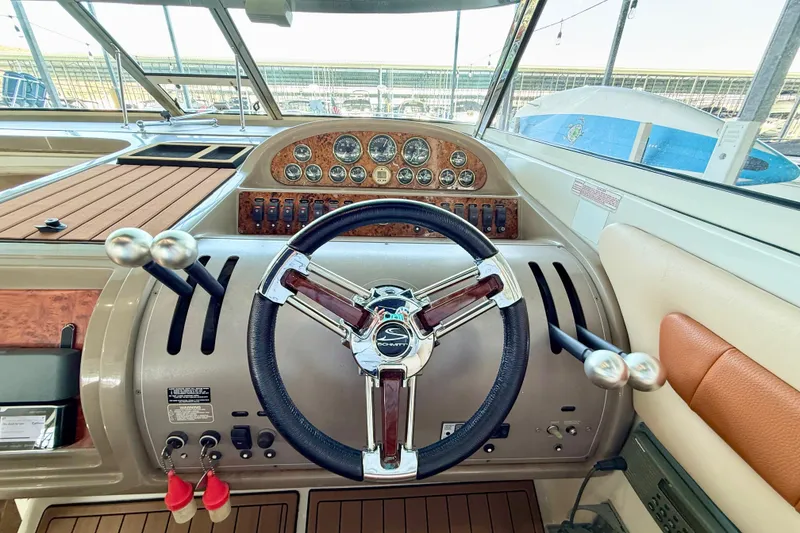 Slide: The Image of 1998 Regal Commodore 402 helm with steering wheel and control panel. - 11