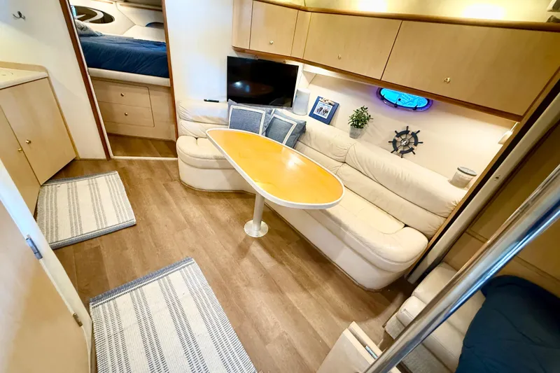 Slide: The Image of Interior of 1998 Regal Commodore 402 yacht with cozy seating and wooden table. - 12