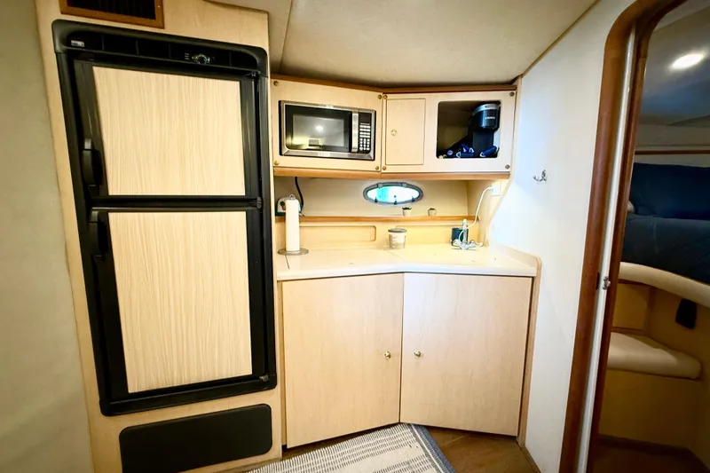 Slide: The Image of 1998 Regal Commodore 402 yacht interior kitchen with fridge, microwave, and sink. - 16