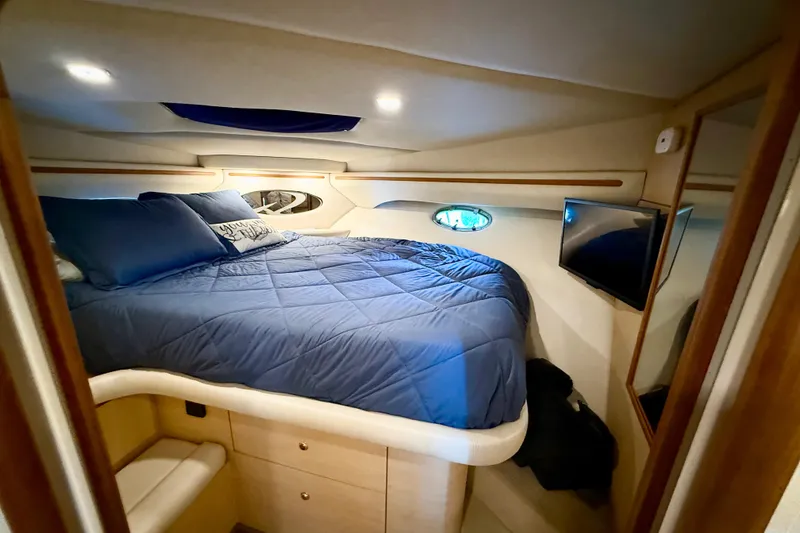 Slide: The Image of Cozy cabin interior of 1998 Regal Commodore 402 yacht with blue bedding and TV. - 17