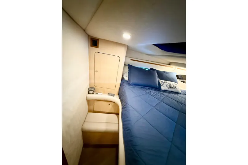 Slide: The Image of Interior cabin of 1998 Regal Commodore 402 yacht with blue bedding and cozy lighting. - 19