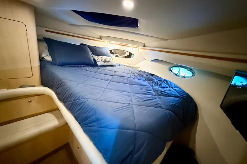 Slide: The Image of Cozy cabin interior of 1998 Regal Commodore 402 with blue bedding and porthole windows. - 20