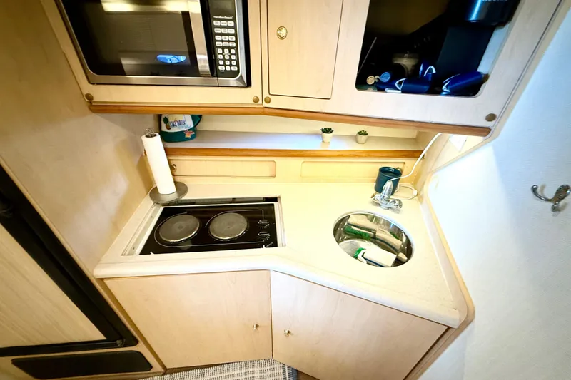 Slide: The Image of Compact kitchen in 1998 Regal Commodore 402 boat with stove, sink, and microwave. - 21