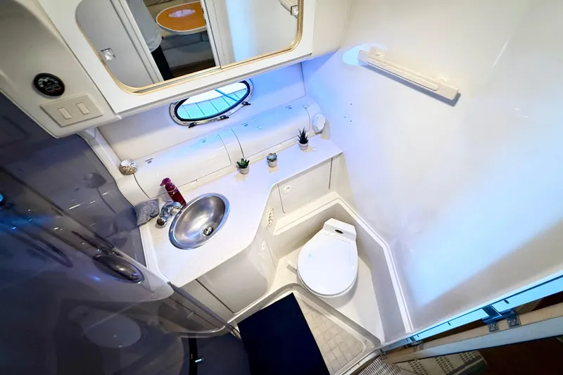 Slide: The Image of 1998 Regal Commodore 402 yacht bathroom with sink, toilet, and porthole window. - 26