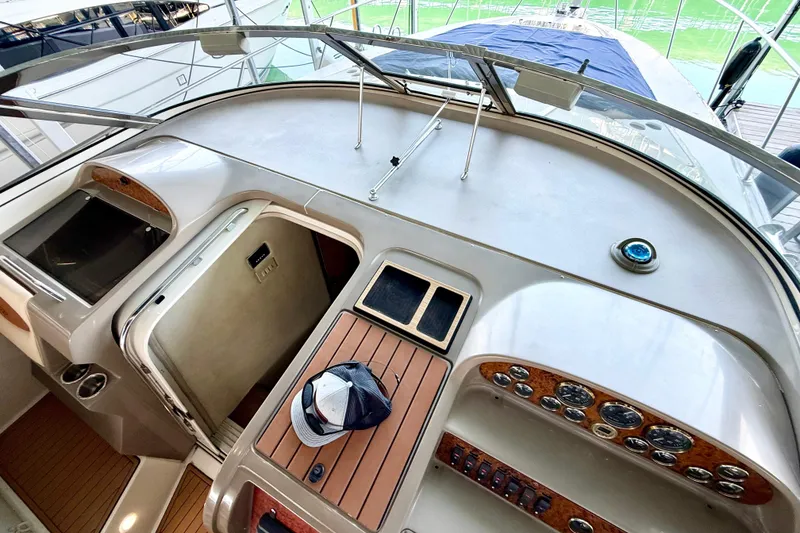 Slide: The Image of 1998 Regal Commodore 402 yacht helm with wood accents and control panel. - 28