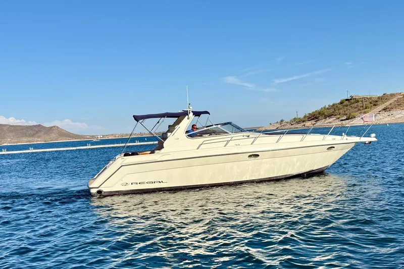 Slide: The Image of 1998 Regal Commodore 402 yacht cruising on a sunny lake with clear blue skies. - 37