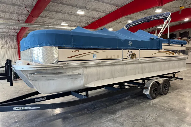 Slide: The Image of 2010 G3 LX3 25 Cruise pontoon boat with blue cover on trailer in warehouse. - 13