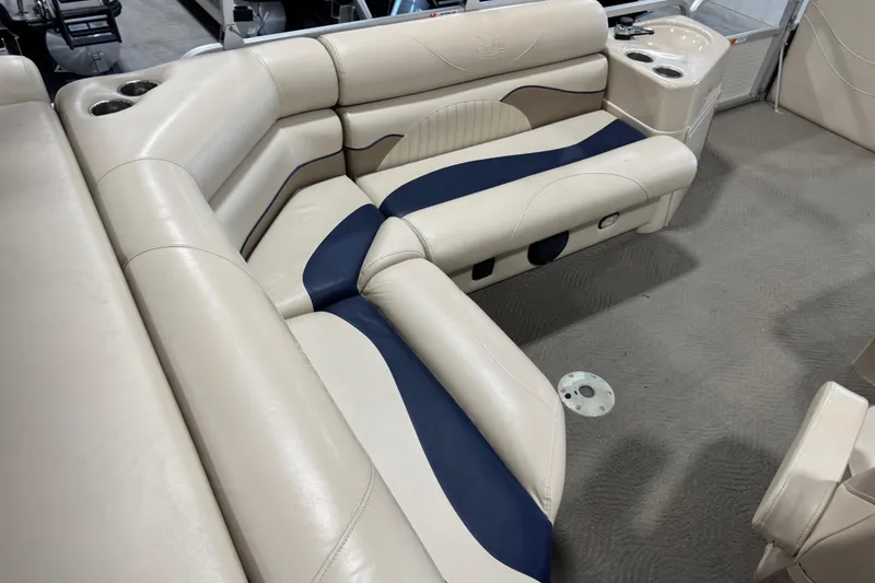 Slide: The Image of Luxurious seating on a 2010 G3 LX3 25 Cruise pontoon boat, featuring beige and navy upholstery. - 8