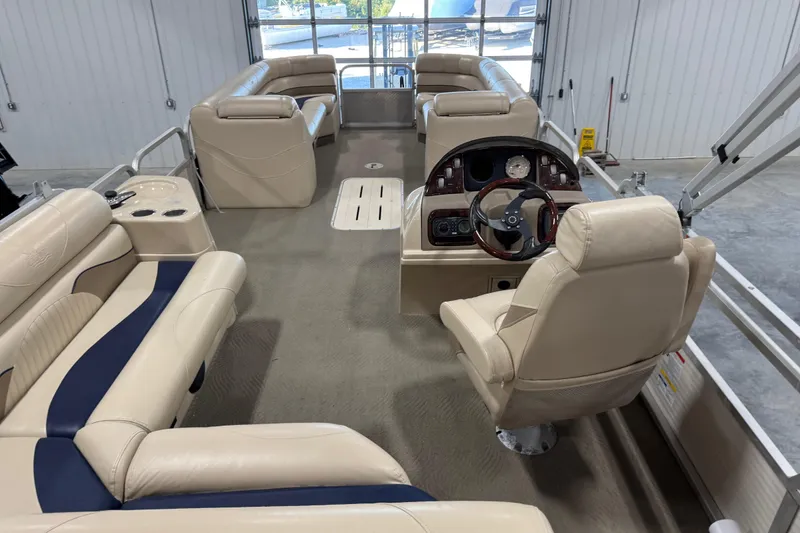 Slide: The Image of Interior of a 2010 G3 LX3 25 Cruise pontoon boat with beige seating and steering console. - 9