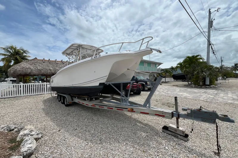 Slide: The Image of 2007 ProKat 2860 Center Console boat on trailer, parked in a tropical setting. - 1