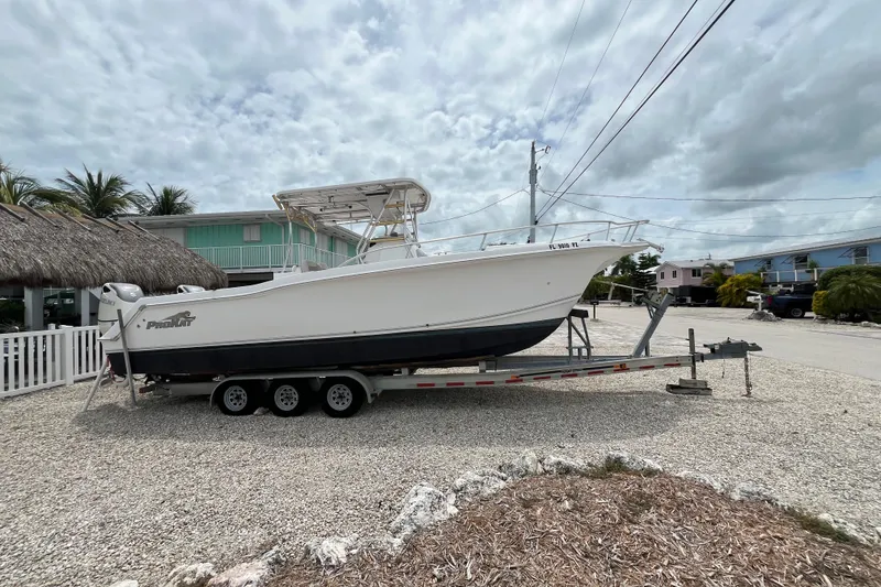 Slide: The Image of 2007 ProKat 2860 Center Console boat on trailer, parked in a residential area. - 2