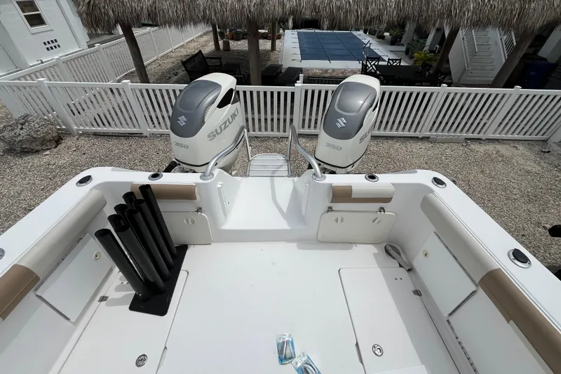 Slide: The Image of 2007 ProKat 2860 Center Console boat with dual Suzuki 350 engines, docked near a patio. - 6