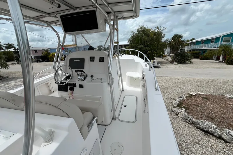 Slide: The Image of 2007 ProKat 2860 Center Console boat with steering wheel and controls, docked near tropical homes. - 8