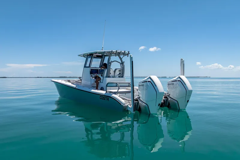 Slide: The Image of 2022 Costa Custom Boats 264 on calm blue water with dual engines. - 10