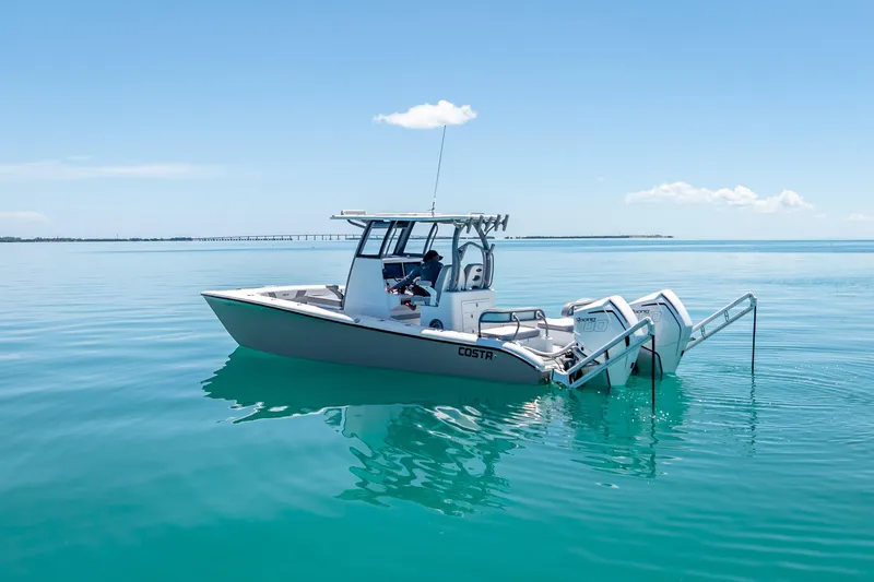 Slide: The Image of 2022 Costa Custom Boats 264 on calm turquoise water under clear blue sky. - 17