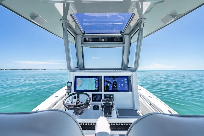 Slide: The Image of 2022 Costa Custom Boats 264 helm with advanced navigation system on calm ocean. - 23