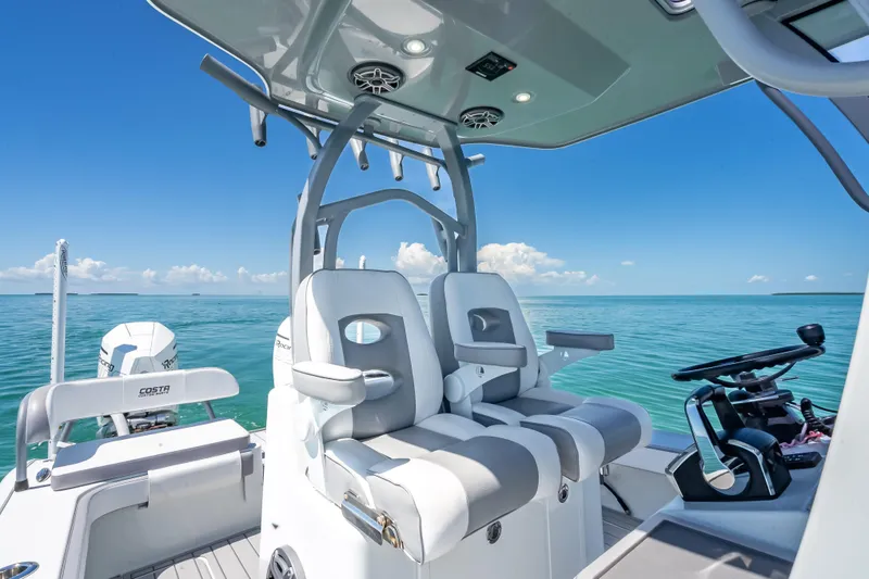 Slide: The Image of 2022 Costa Custom Boats 264 interior with dual seats, ocean view, and clear blue sky. - 30
