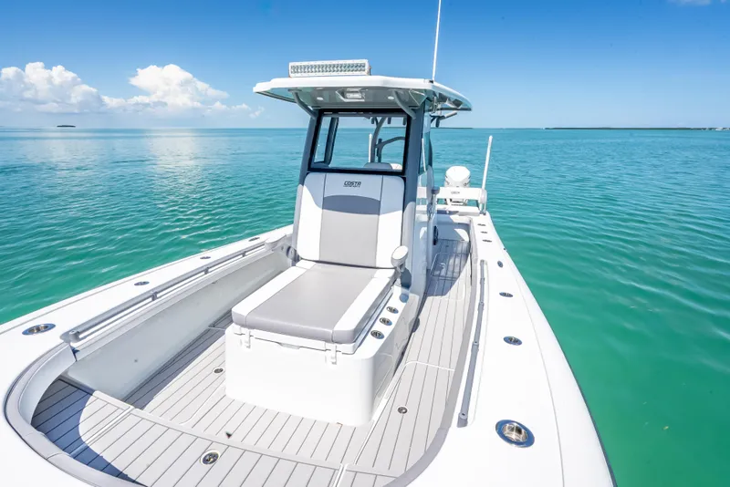 Slide: The Image of 2022 Costa Custom Boats 264 on serene turquoise water, showcasing sleek design and spacious deck. - 31