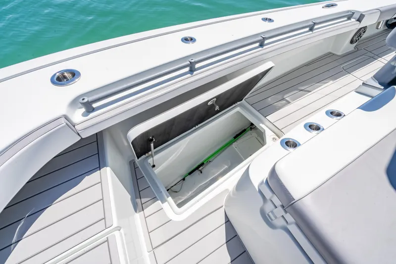Slide: The Image of 2022 Costa Custom Boats 264 deck with open storage compartment, sleek design, and cup holders. - 36