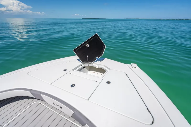 Slide: The Image of 2022 Costa Custom Boats 264 on calm blue water, open hatch on deck. - 37