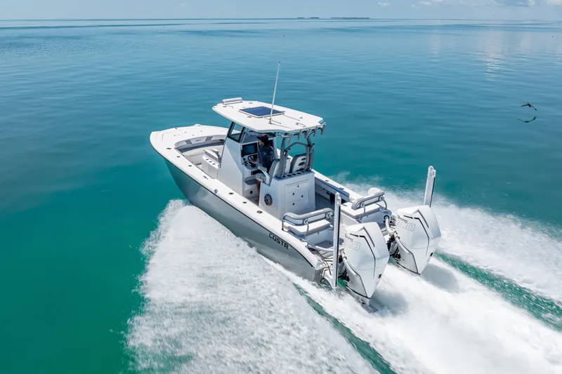 Slide: The Image of 2022 Costa Custom Boats 264 cruising on clear blue water, showcasing sleek design and powerful engines. - 4