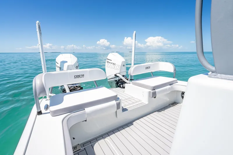 Slide: The Image of 2022 Costa Custom Boats 264 on clear blue water, featuring dual engines and seating. - 42