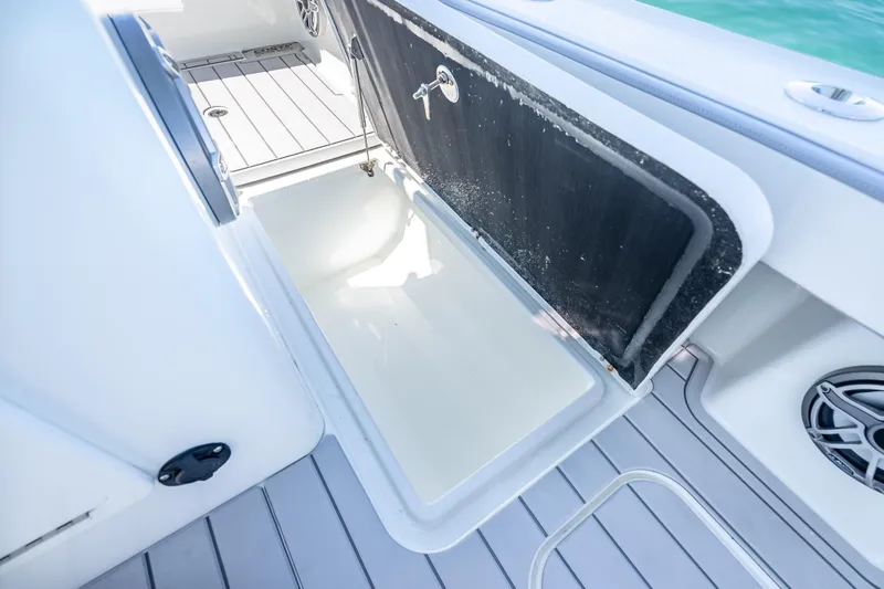 Slide: The Image of 2022 Costa Custom Boats 264 interior storage compartment with open hatch, showcasing sleek design. - 53