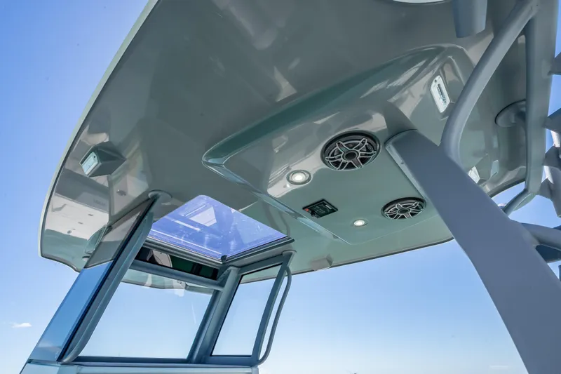 Slide: The Image of 2022 Costa Custom Boats 264, sleek boat roof with speakers and lights against blue sky. - 56