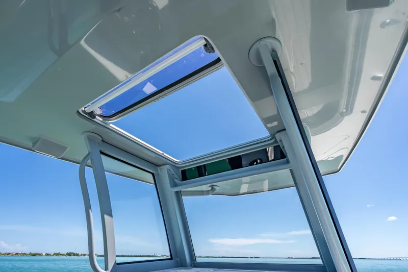 Slide: The Image of 2022 Costa Custom Boats 264 with open sunroof, showcasing clear blue sky and ocean. - 57