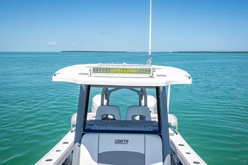 Slide: The Image of 2022 Costa Custom Boats 264 on serene blue ocean waters. - 58