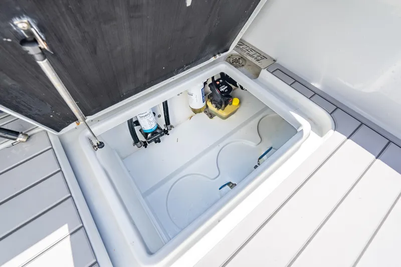 Slide: The Image of Storage compartment of 2022 Costa Custom Boats 264, featuring pumps and equipment. - 62
