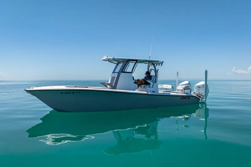 Slide: The Image of 2022 Costa Custom Boats 264 on calm blue water under clear sky. - 9