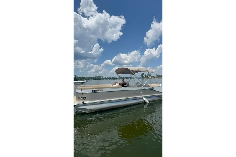 Slide: The Image of 2023 Tahoe Pontoon Cascade Rear Lounger on a sunny lake with blue skies. - 0