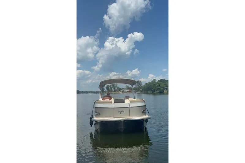 Slide: The Image of 2023 Tahoe Pontoon Cascade Rear Lounger on a serene lake under a blue sky. - 2