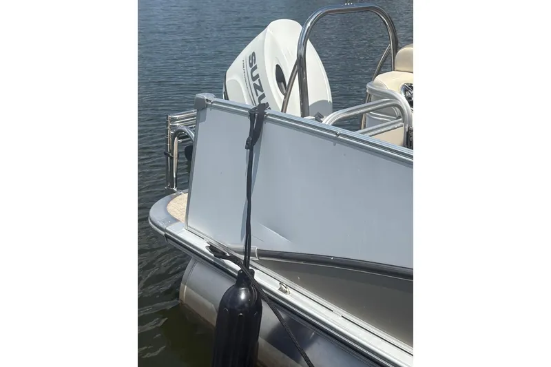 Slide: The Image of 2023 Tahoe Pontoon Cascade Rear Lounger with Suzuki outboard motor on water. - 4