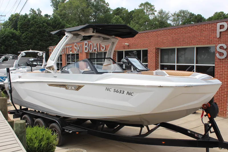 The Image of 2024 Tigé Ultré 25ZX boat on trailer at dealership, showcasing sleek design. - 1
