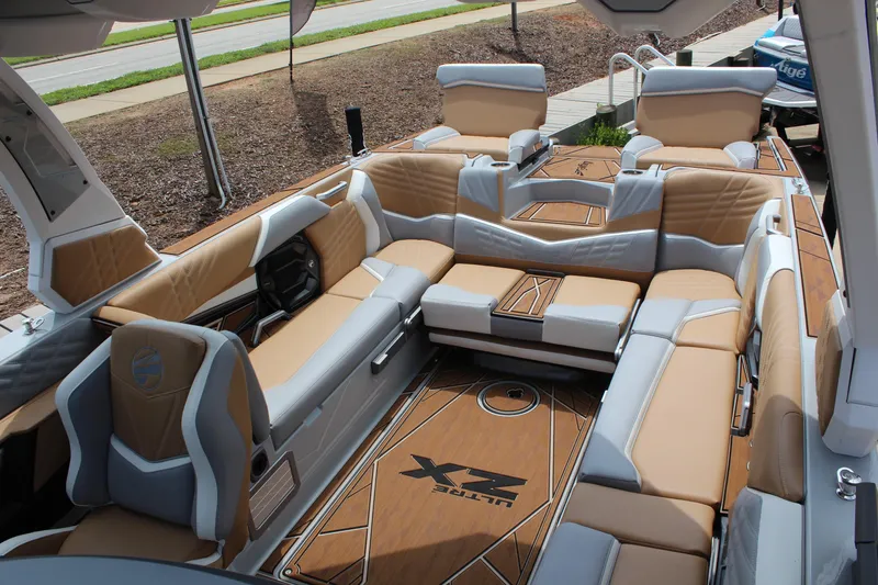 Slide: The Image of 2024 Tigé Ultré 25ZX boat interior with luxurious tan and gray seating. - 11