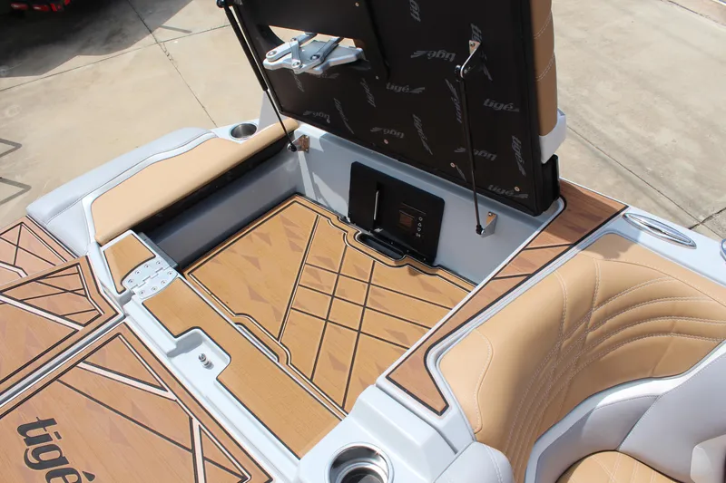 Slide: The Image of 2024 Tigé Ultré 25ZX boat interior with tan seating and stylish deck design. - 12