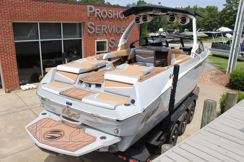 Slide: The Image of 2024 Tigé Ultré 25ZX boat with sleek design, parked at a service center. - 3