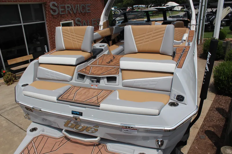 Slide: The Image of 2024 Tigé Ultré 25ZX boat with tan and white seating, displayed outdoors. - 4