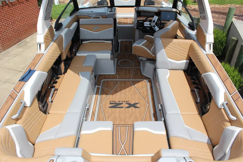 Slide: The Image of 2024 Tigé Ultré 25ZX boat interior with luxurious tan and gray seating. - 5