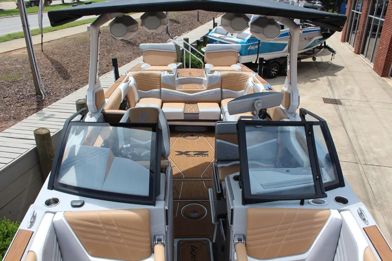 Slide: The Image of 2024 Tigé Ultré 25ZX boat interior with tan and white seating, open windshield, and modern design. - 8