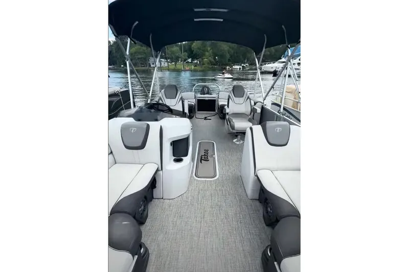 Slide: The Image of 2023 Tahoe Pontoon Sport LTZ Quad Lounger on a serene lake, featuring luxurious seating. - 5