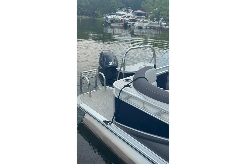 Slide: The Image of 2023 Tahoe Pontoon Sport LTZ Quad Lounger docked on a calm lake. - 6