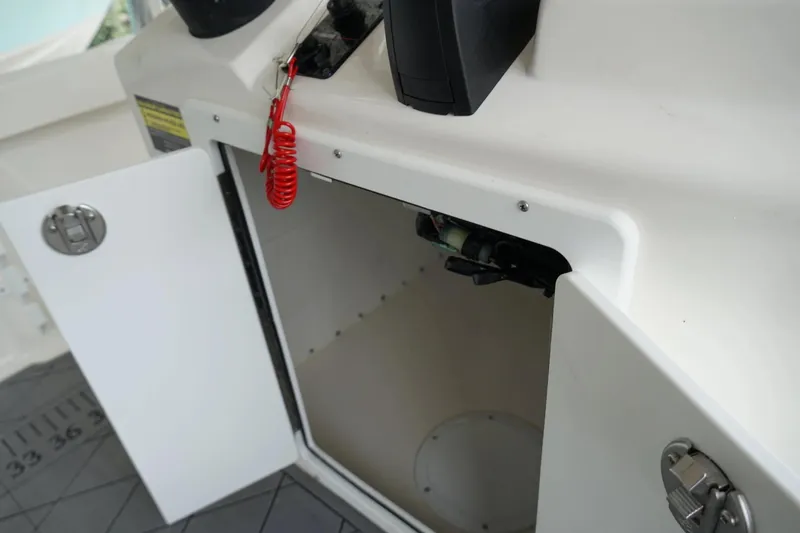 Slide: The Image of Open storage compartment on 2026 Defiance CATALINA 192 boat with red safety cord. - 27